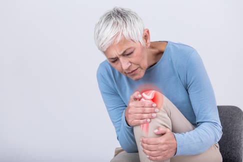 Frau mit Knieschmerzen aufgrund von Osteoarthritis