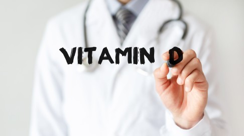 Arzt schreibt Vitamin D auf eine Tafel.