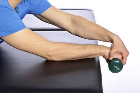 Die freie Hand umschließt die betroffene Hand. © Gelenk-Klinik Exzentrische Übung bei Tennisarm, Stufe 1