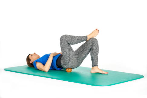 Platzieren Sie den Massageball unter dem Gesäß und führen Sie Rollbewegungen durch. © Gelenk-Klinik Massage der Gesäßmuskulatur in Rückenlage
