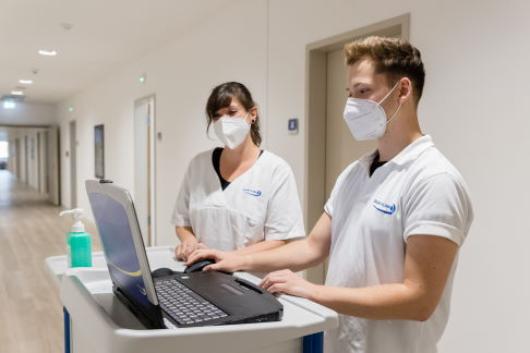 Unsere speziell ausgebildeten Pflegekräfte unterstützen Sie im Genesungsprozess. © Gelenk-Klinik Pflegekräfte dokumentieren am Laptop.