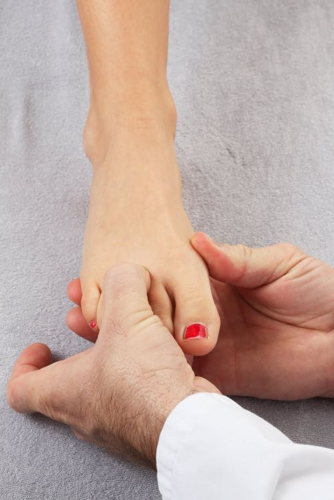 Das Morton Neurom kann manuell durch den sog. Mulders Click untersucht werden. Dabei ertastet der Arzt das Morton Neurom zwischen den Zehenstrahlen. © Gelenk-Klinik Hände des Arztes tasten Fuß ab