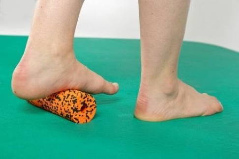 Übung mit Faszienrolle. © Gelenk-Klinik Übung zur Durchblutungsförderung der Plantarfaszie mit einer Faszienrolle
