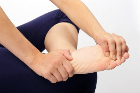Greifen Sie den Fuß an der Ferse und am Vorfuß. © Gelenk-Klinik Übung zur Mobilisation des unteren Sprunggelenks: Ausgangsstellung