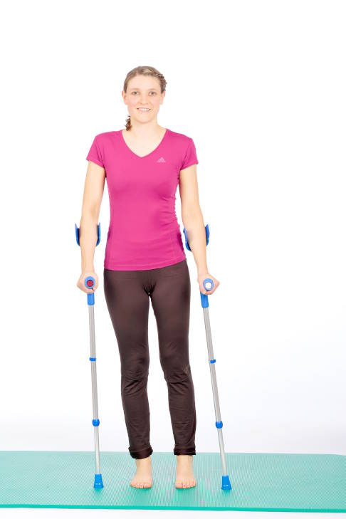 Verlagern Sie Ihr Gewicht auf das rechte Bein. © Gelenk-Klinik Frau im Stand mit Krücken, Gewicht auf dem rechten Bein.