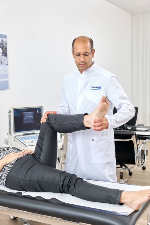 Untersuchung des Piriformis-Syndroms durch den Hüftspezialisten: Der Patient drückt das Bein gegen Widerstand nach außen. © Gelenk-Klinik Untersuchung des Piriformis-Syndroms durch den Hüftspezialisten