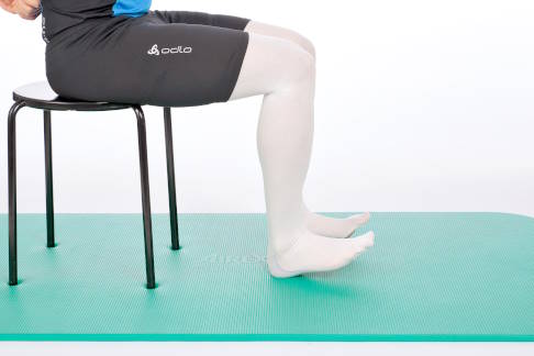 Rollen Sie nun die Füße zurück auf die Ferse. © Gelenk-Klinik Sitz auf einem Stuhl, die Füße auf der Ferse.