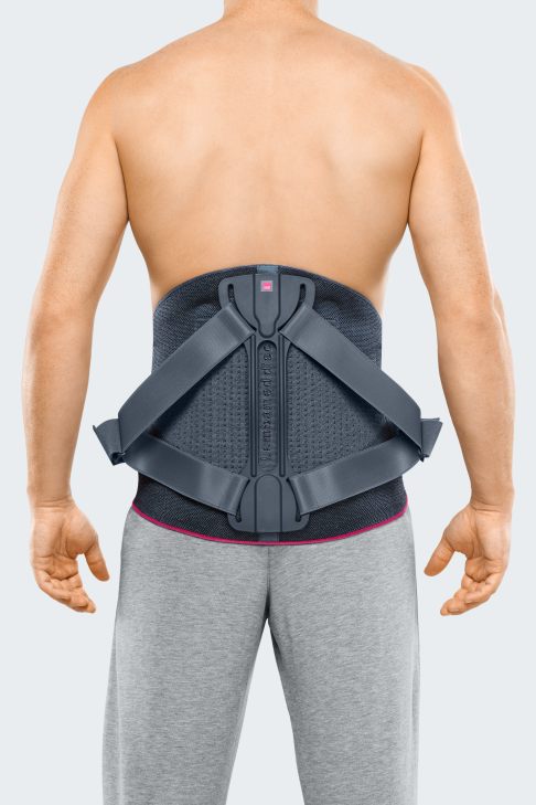 Nach einer wirbelsäulenversteifenden Operation (Spondylodese) bei Morbus Scheuermann trägt der Patient in den ersten Wochen ein Lumbalkorsett oder Lumbalmieder. Es stützt den operierten Rückenbereich und stellt ihn ruhig. ©medi GmbH & Co.KG Lumbalkorsett nach Operation bei Morbus Scheuermann