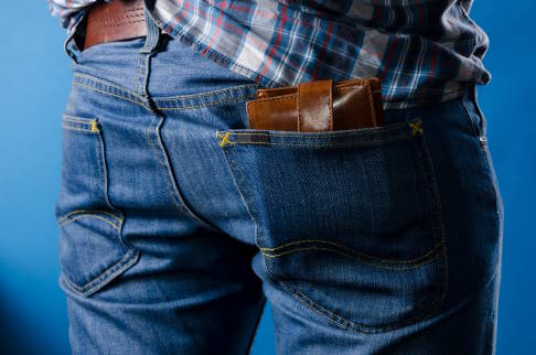 Das Piriformis-Syndrom entsteht u. a. durch Fehlbelastungen. Ein häufiger Grund für eine Überlastung des Piriformis-Muskels ist das einseitige Sitzen auf dem in der Gesäßtasche steckenden Geldbeutel. © smutnypan, Adobe Mann mit Geldbeutel in der rechten Hosentasche