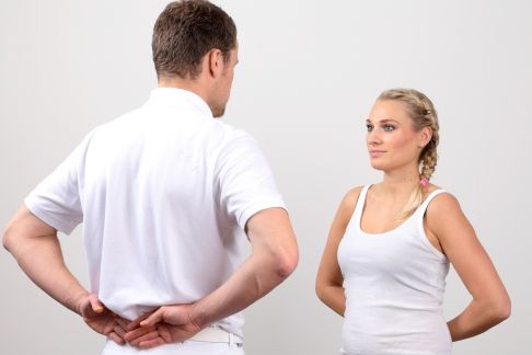 Für den Schürzengriff muss der Patient seinen Arm nach hinten abspreizen, was ihm mit Schulterarthrose oder gerissener Bizepssehne schwerfällt oder unmöglich ist. © Gelenk-Klinik Schürzengriff bei Schulterarthrose.