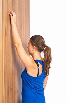 Laufen Sie mit den Fingern langsam die Wand hinauf. © Gelenk-Klinik Wand mit Fingern hochlaufen